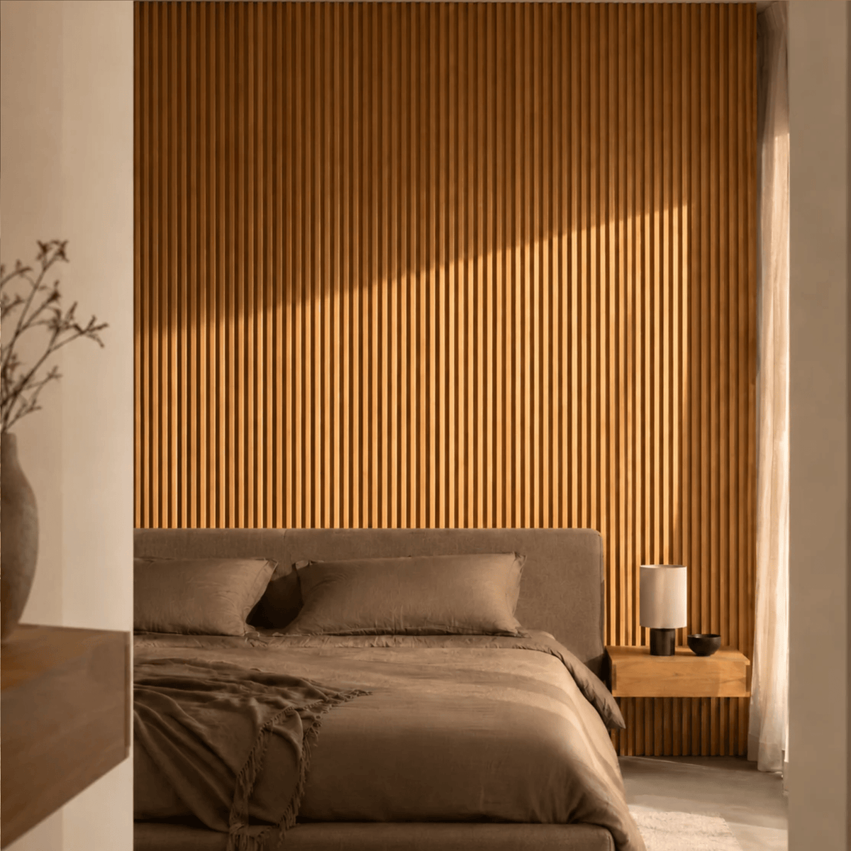 Pared de dormitorio revestida con panel WPC de listones color madera clara detrás de la cama